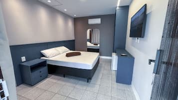 Un dormitorio moderno con una cama, mesitas de noche, un televisor y un espejo.