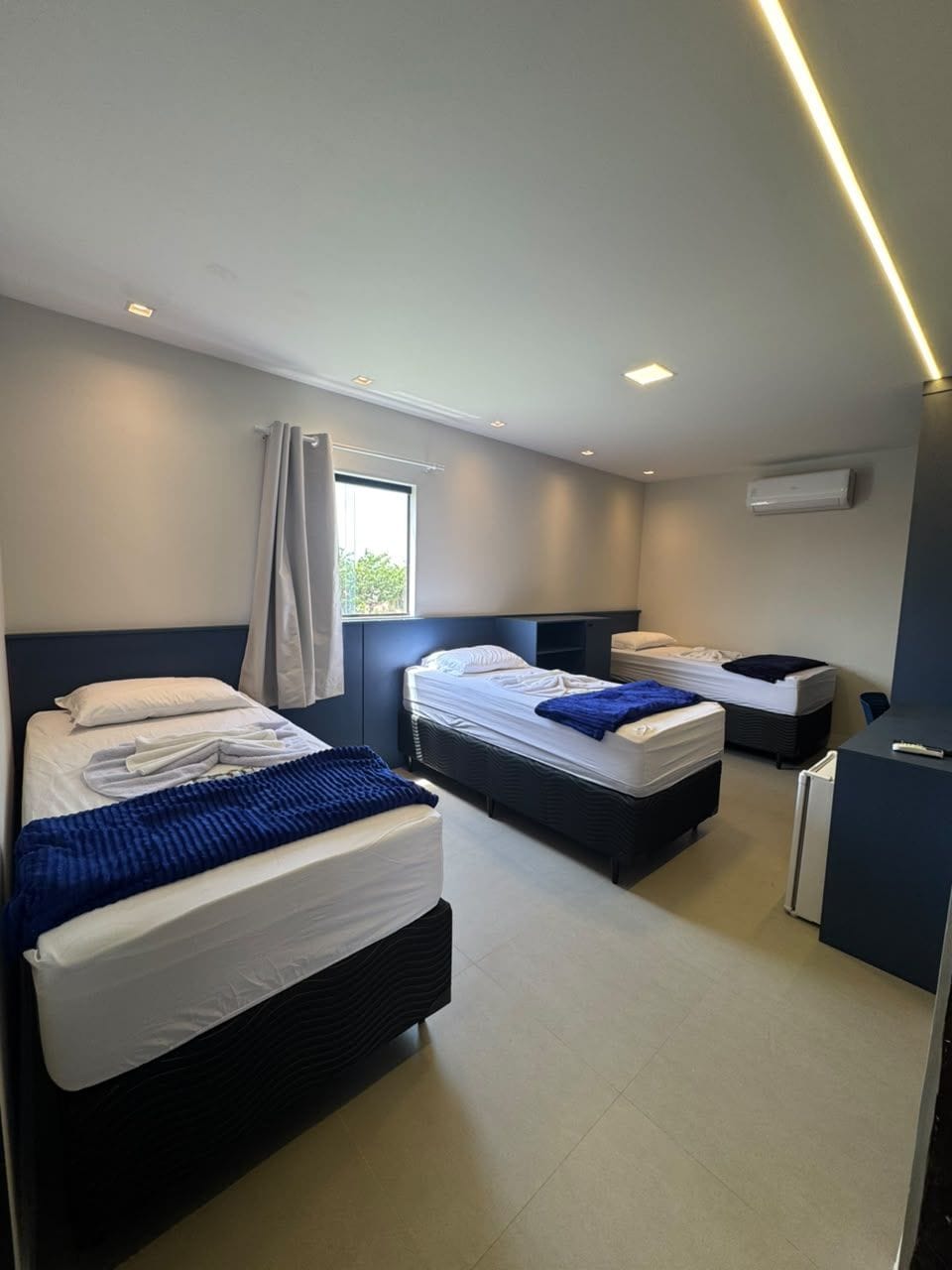 Habitación de hotel moderna con dos camas, un escritorio y una ventana.