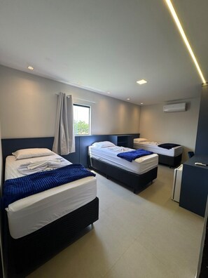 A modern hotel room with two beds, a desk, and a window. - Sol Flats (Sao Joao Da Barra)