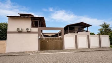 Una propiedad residencial con acceso restringido, un edificio de dos pisos, un balcón y un espacio al aire libre cubierto.