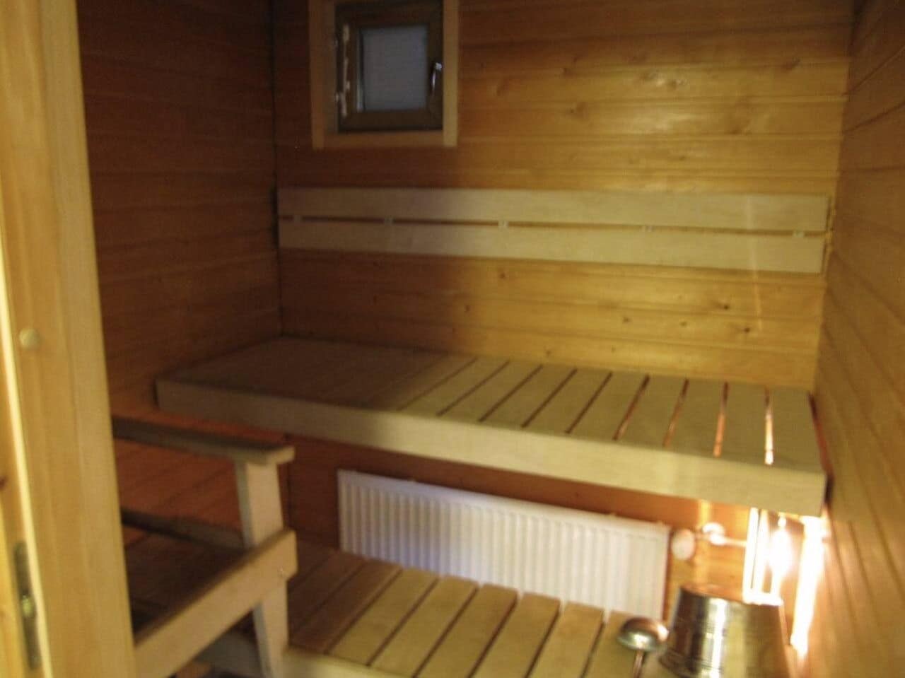 A sauna with wooden benches and a small window.