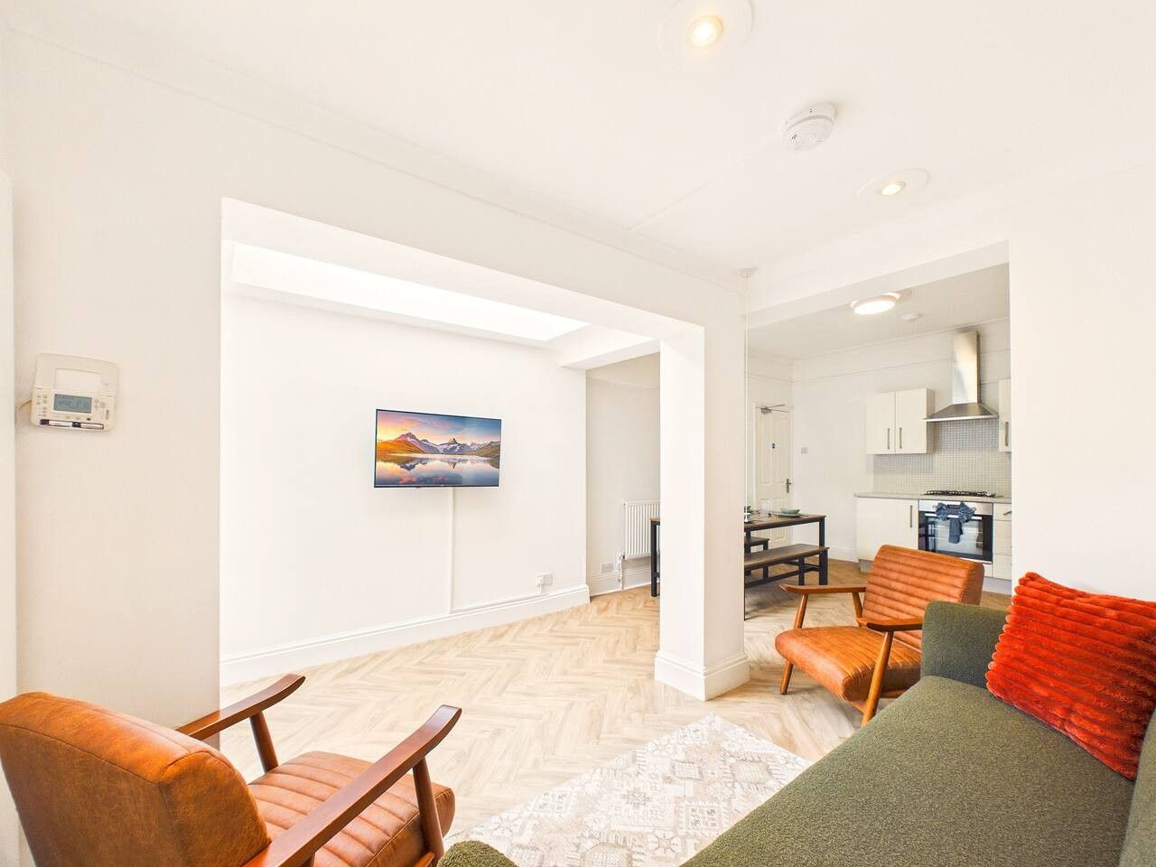 Una sala de estar moderna con chimenea, comedor y cocina.