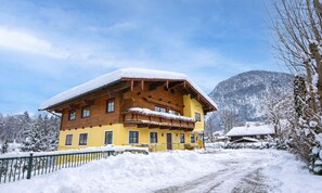 A wooden building with a yellow facade, a balcony, and a snow-covered roof. - Hotel Dax by Alpeffect Hotels (Lofer)