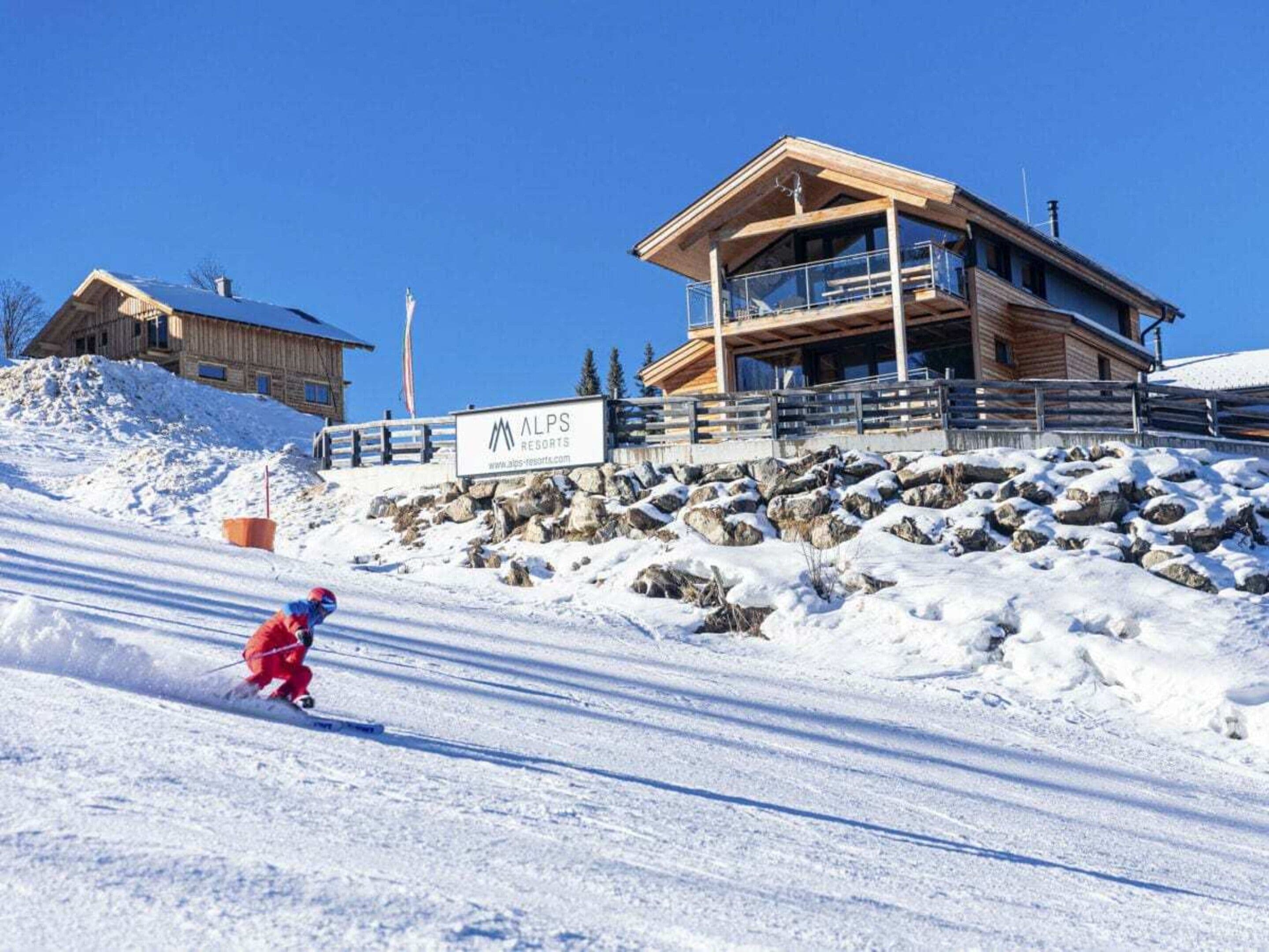 A ski resort with a wooden lodge and a sign for ALPS RESORTS.