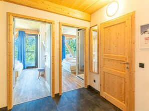 A hallway with wooden doors leading to a balcony and a bedroom. - Cabin in Pichl Near Schladming With Sauna (Schladming)