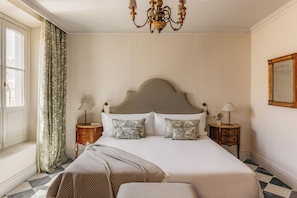 A hotel room with a large bed, a chandelier, a window with curtains, and a checkered floor. - Casa Alameda 1760 Member Of Melia Collection (Cadiz)