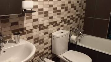 Un baño con lavamanos, inodoro, bidé y bañera.