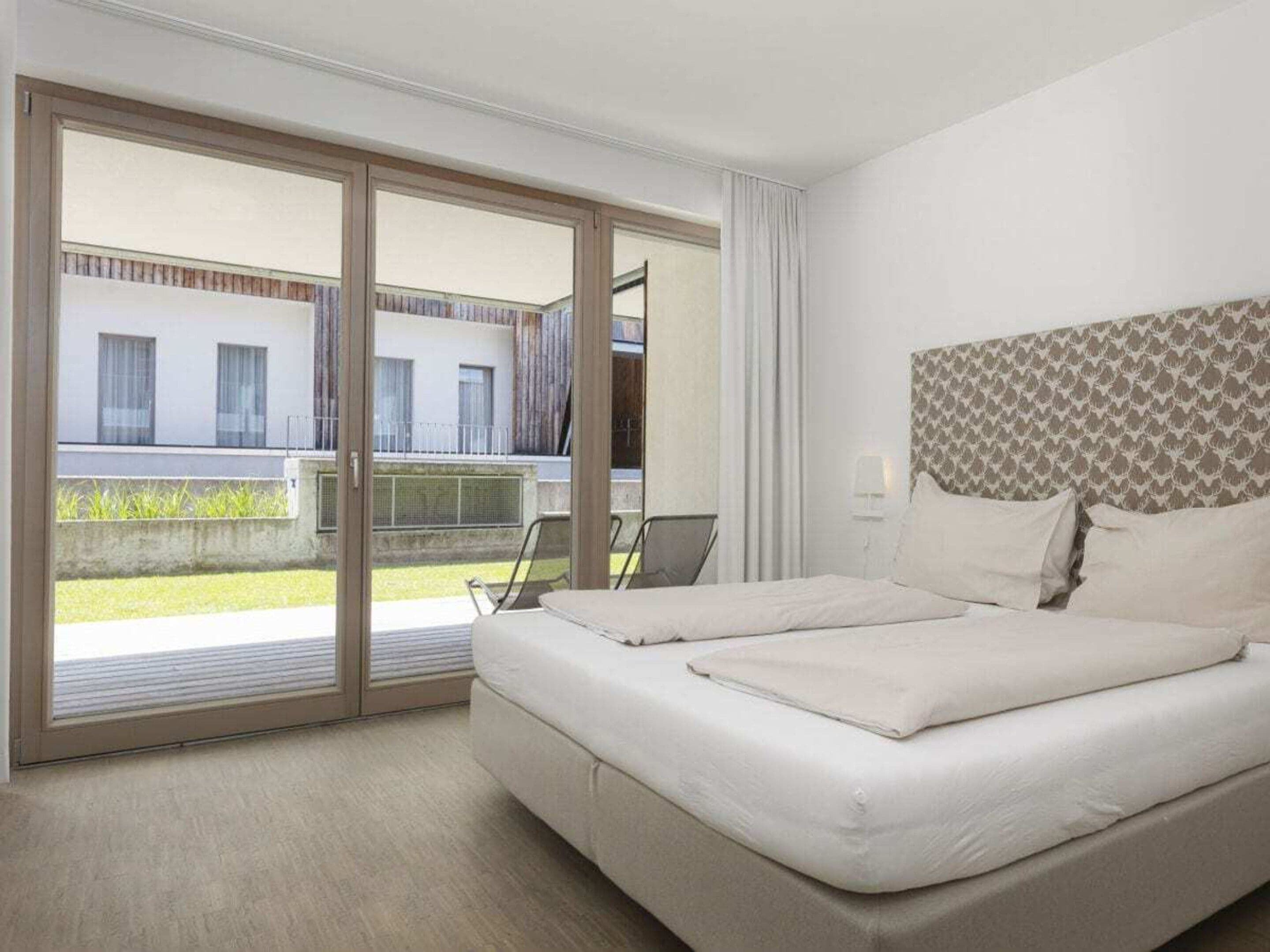 Una habitación de hotel con cama, escritorio y vistas al exterior.