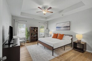 A modern bedroom with a bed, bedside lamps, a ceiling fan, a bookshelf, and a TV. - 4Bedroom 3 Bath Athletes Retreat minutes near the Rome Tennis Center! Pool Hot Tub + Spa (Rome)