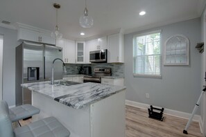 A modern kitchen with white cabinetry, a marble island, stainless steel appliances, and pendant lighting. - < 1 Mi to Marta! Extended Getaway 3 Mi to Dtwn (Atlanta)