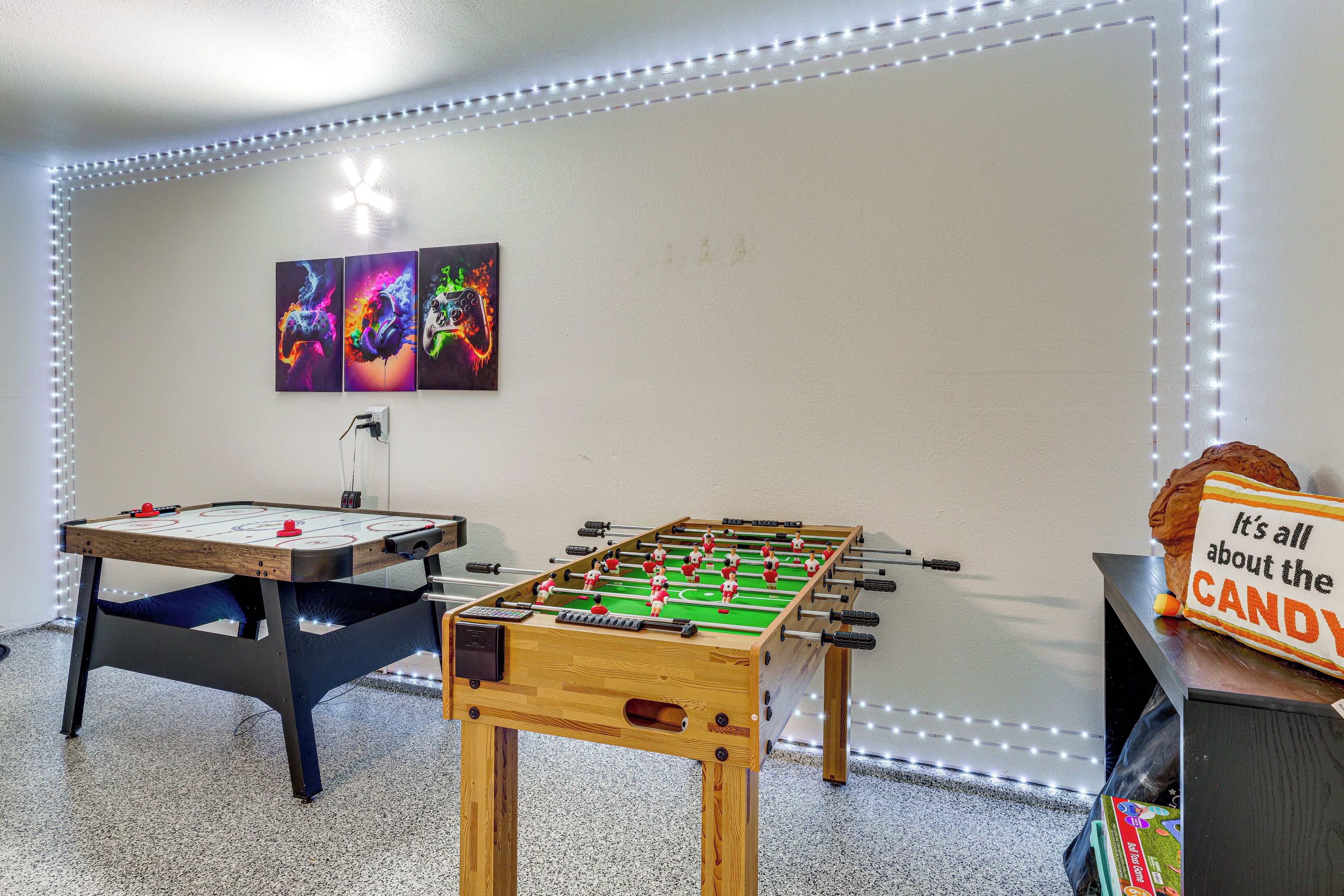Una habitación con dos mesas de fútbol de mesa, una en primer plano y otra al fondo.