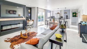 Ein modernes Wohnzimmer mit einer Couch, einem Couchtisch und einem Essbereich mit Stühlen und Tisch.
