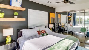 Ein modernes Hotelzimmer mit einem großen Bett, einem Schreibtisch, einem Spiegel und Blick ins Freie.