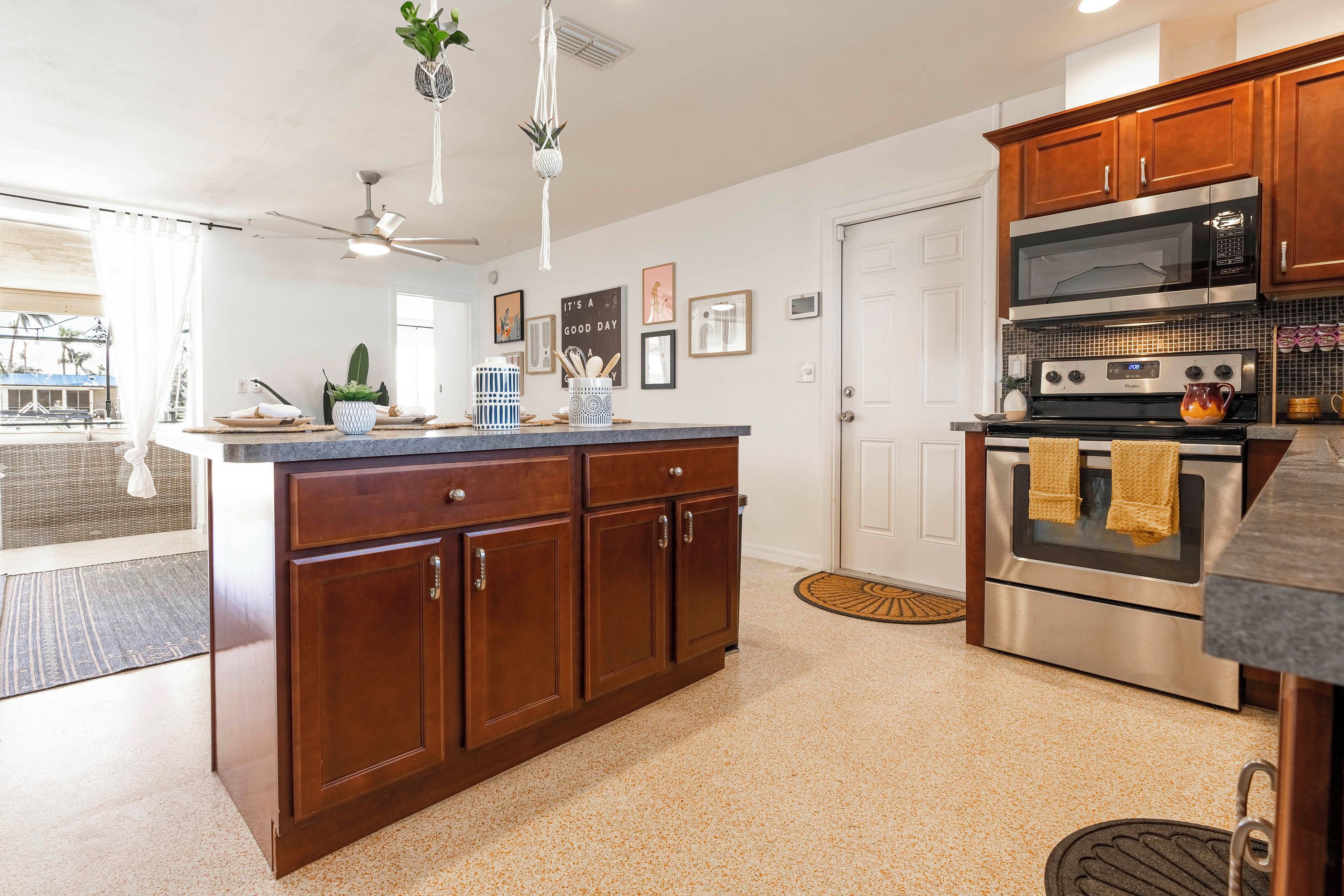 A kitchen with wooden cabinets, a stainless steel oven, and a granite countertop.