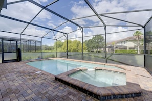 A swimming pool with a glass enclosure, surrounded by a brick patio. - Solterra Resort Home w/ AI Vending & Private Pool! (Davenport)