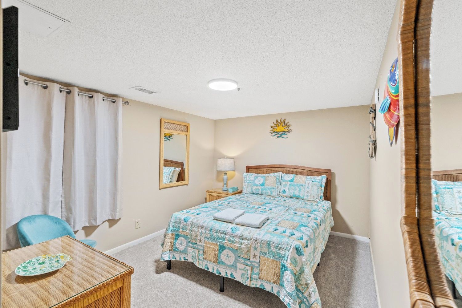 Une chambre à coucher comprenant un lit, une chaise, une petite table, un miroir et un élément de décoration murale.