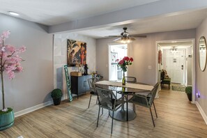 A dining area with a round table, chairs, a ceiling fan, and a painting on the wall. - < 1 Mi to Fort Jackson: Condo w/ Private Patio (Columbia)