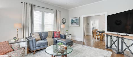 A living room with a sofa, coffee table, and a television.
