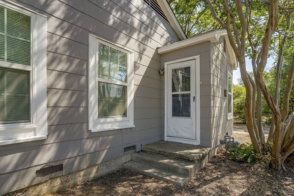 A residential house with a front porch, a door, and two windows.