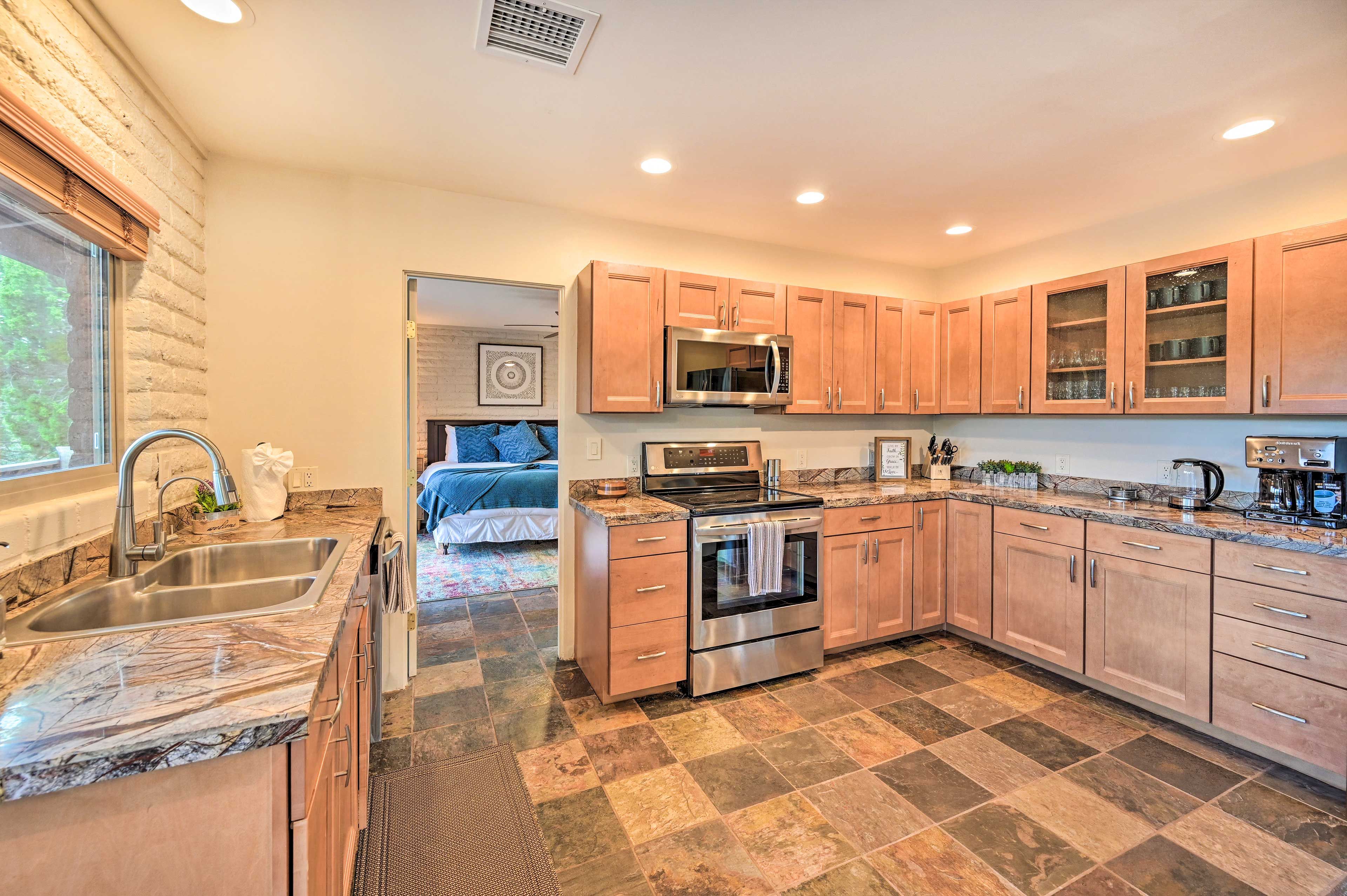 A modern kitchen with granite countertops, stainless steel appliances, and wooden cabinets.