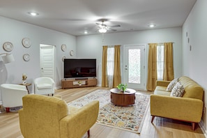 A living room with a flat-screen TV, two sofas, a coffee table, and a patterned rug. - Screened Porch: Newly Built Townhome in Madison (Madison)