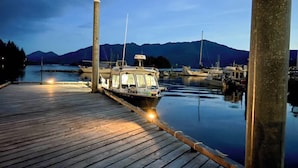 A boat docked at a pier with a mountain backdrop. - Ketchikan Oceanfront Retreat Dock On-site, Beach (Ketchikan)