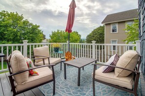 A deck with outdoor furniture, a table, and an umbrella.