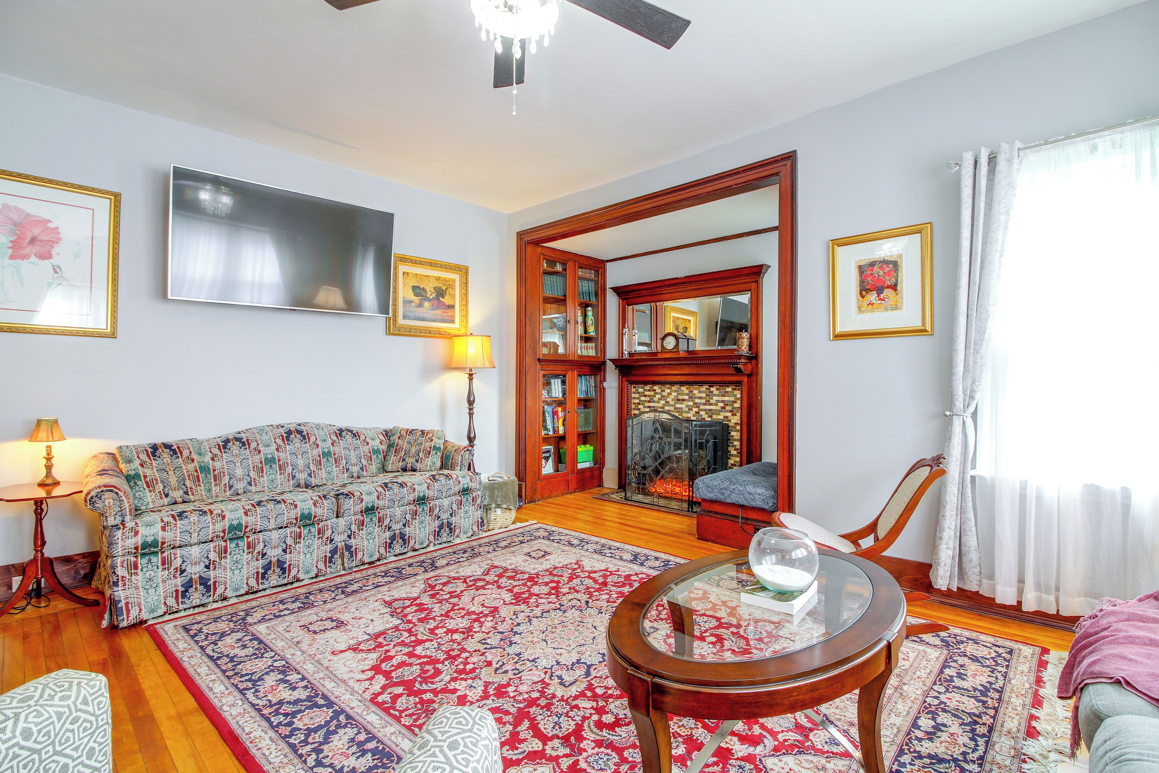 A living room with a sofa, a coffee table, a television, and a fireplace.