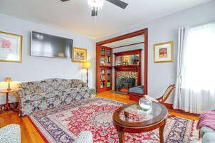 A living room with a sofa, a coffee table, a television, and a fireplace.