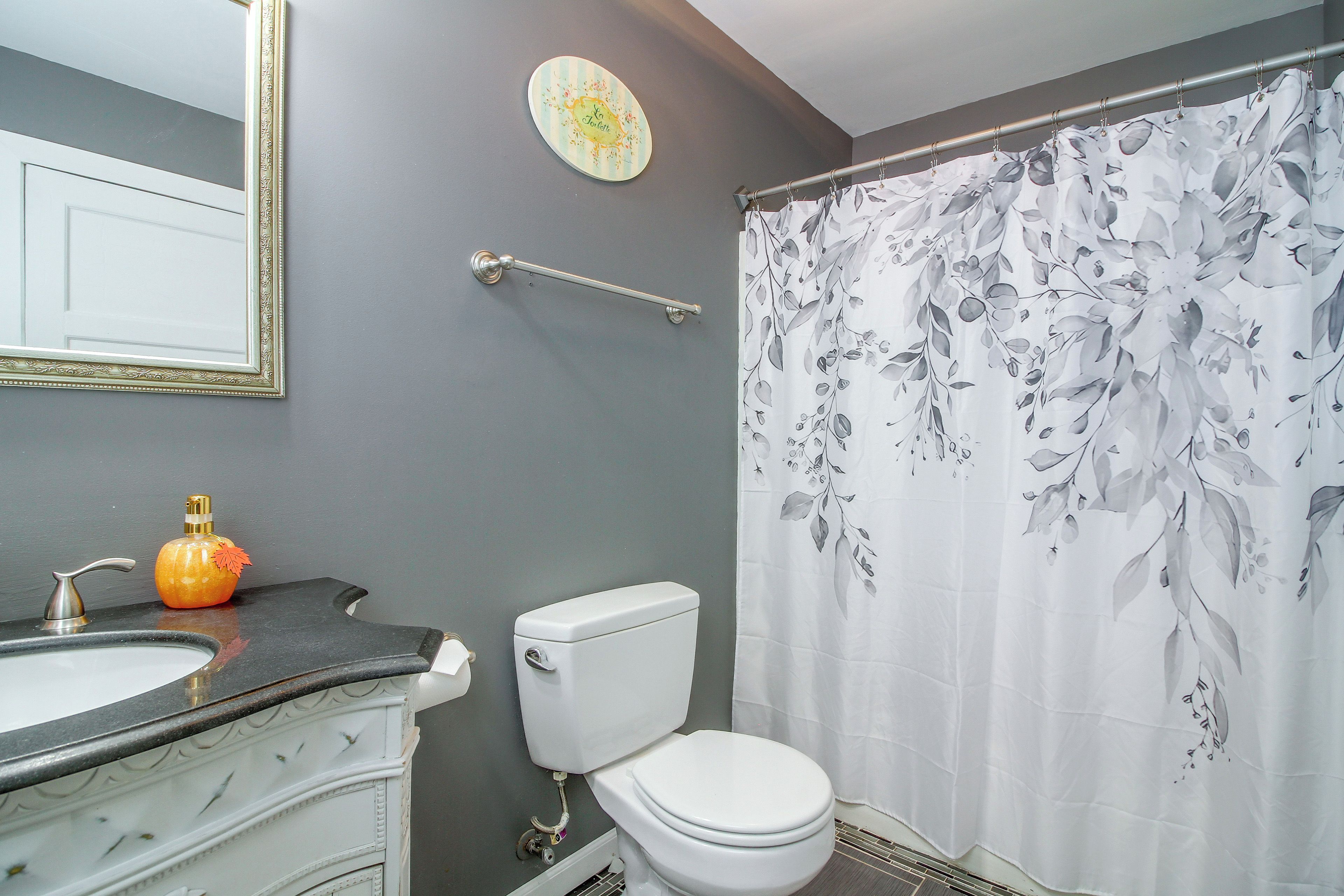 Une salle de bain équipée de toilettes, d’un lavabo et d’un rideau de douche.
