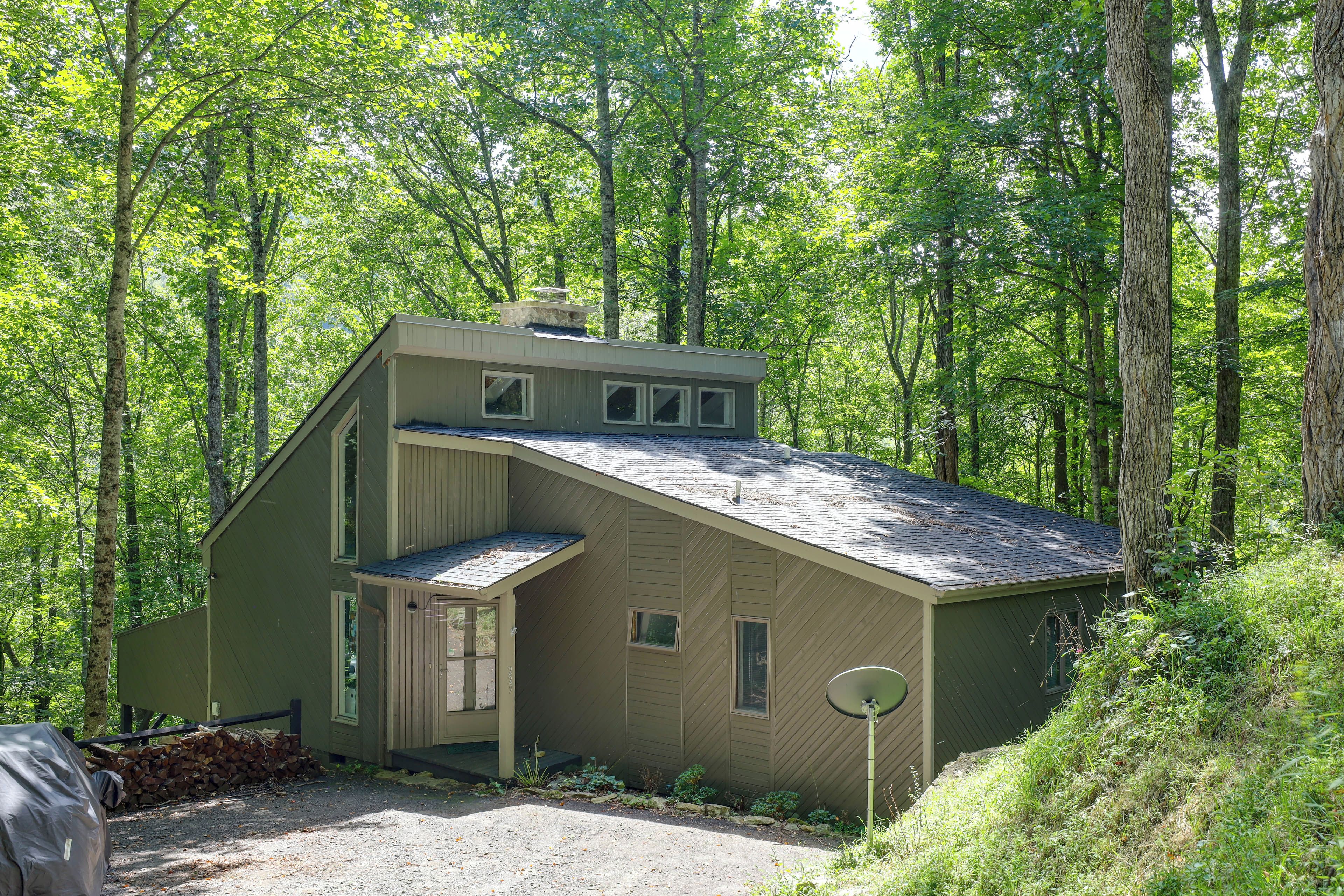 A single-story house with a sloped roof, a front porch, and a satellite dish.