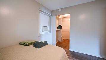 Een slaapkamer met een bed, een kast en een gang naar een badkamer.