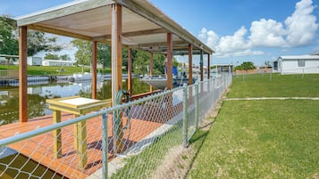 A covered outdoor area with a wooden deck, a table, and chairs.
