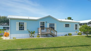 A single-story house with a front porch and a small deck.