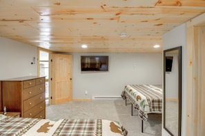 A room with wooden ceiling, a bed with a plaid bedspread, a dresser, and a mirror. - 'riverside Escape' Ride, Paddle, Relax (Crosby)