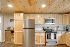 A kitchen with wooden cabinets, stainless steel appliances, and a marble countertop. - 'riverside Escape' Ride, Paddle, Relax (Crosby)