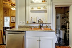 A kitchen with a built-in dishwasher, a sink with a single faucet, and a countertop.