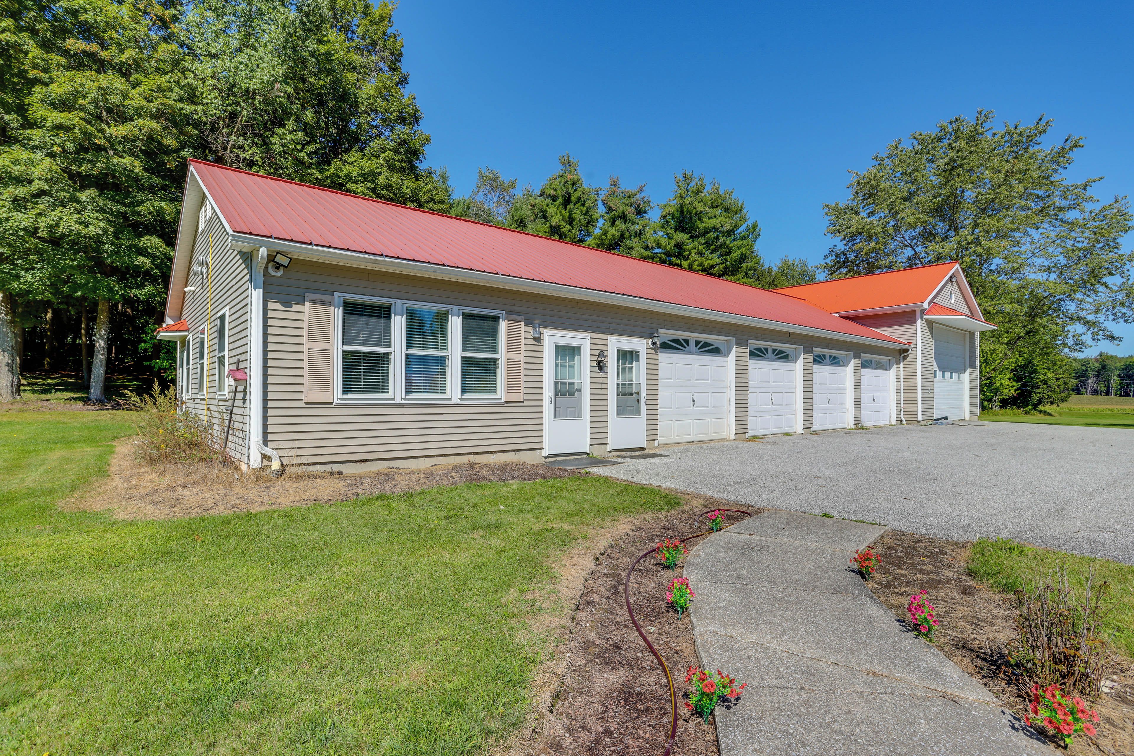 A single-story building with a red roof, a garage, and a driveway leading to the entrance.