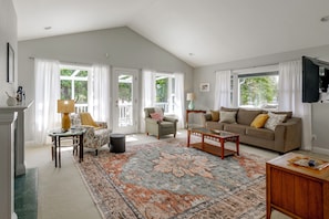 A spacious living room with a high ceiling, a large window, a sofa set, a coffee table, and a television mounted on the wall. - 2 Mi to Ocean & Coastal Trails! Mckinleyville Home (McKinleyville)