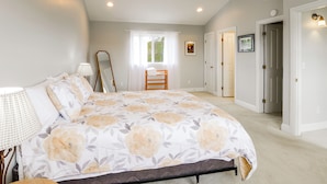 Un dormitorio con cama, una silla, una ventana y una puerta.