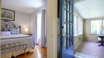 A bedroom with a bed, a bedside table, a lamp, and a window with curtains.