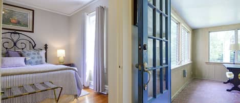 A bedroom with a bed, a bedside table, a lamp, and a window with curtains.