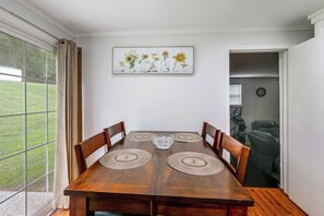 A dining room with a wooden table, four chairs, and a painting of sunflowers on the wall. - Hickory Haven w/ Home Gym & Quiet Backyard Porch (Hickory)