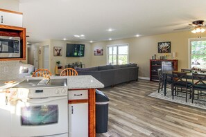 A compact living space with a kitchenette, a dining area, and a seating area with a sofa. - Cozy Highland Cow Retreat - 4 Mi to JMU (Penn Laird)