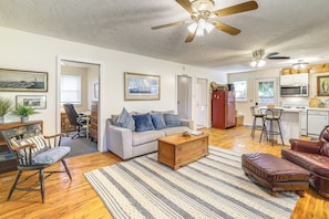 A spacious living room with a sofa, coffee table, and leather chairs. There is a kitchen area with a refrigerator and microwave. - 3 Bicycles & Peek-a-boo Lake Views! Barker Gem (Barker)