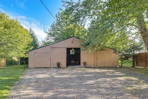 A single-story wooden building with a gravel driveway and a covered outdoor seating area.