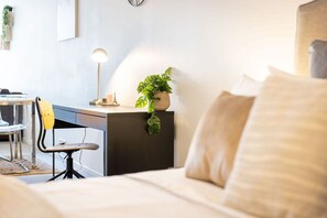 A bedroom with a bed, a desk, a chair, a lamp, and a potted plant. - Cozy Studio CBD Stay Next to Darling Harbour (Sydney)