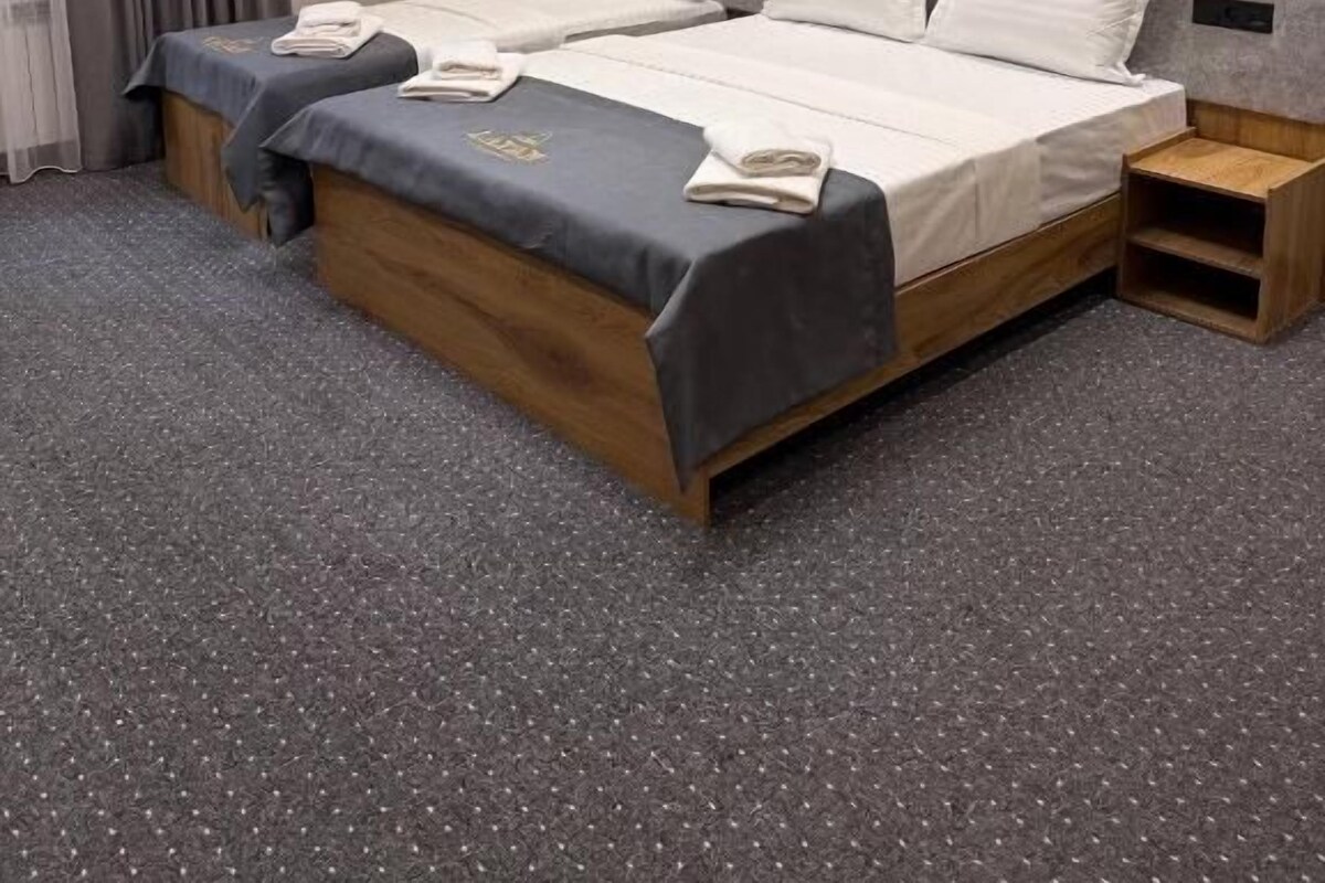 Habitació d'hotel amb un llit doble, una taula de nit i un aire condicionat.