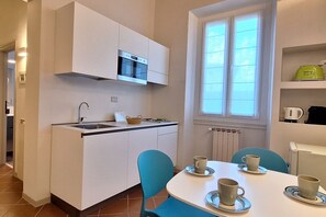 A compact kitchen with white cabinets, a built-in oven, and a window above the sink. - Casa Mimosa is a typical old Florentine apartment, designed for the relaxation of our guests, we are in the lively central district Oltrarno.At Casa Mimosa you can find a kitchen living room with sofa bed and study corner, a bedroom with double bed, a ba (Florence)