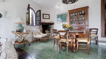 Une pièce de style traditionnel, dotée d’une cheminée, de meubles en bois et d’une table à manger.